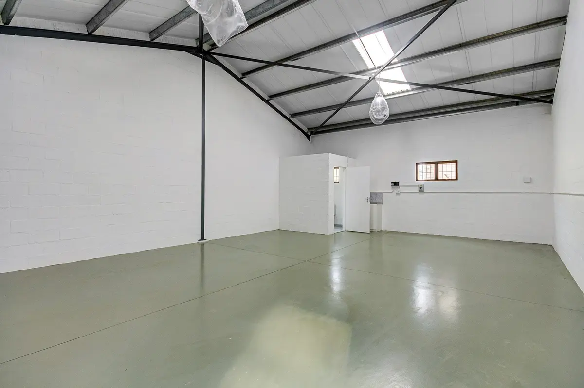Inside a factory unit: white walls, steel roof trusses and a polished floor